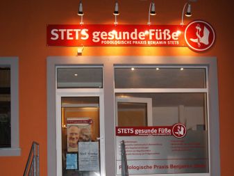 Werbeschild mit Strahlern und Schaufensterbeschriftung - Nachtwirkung